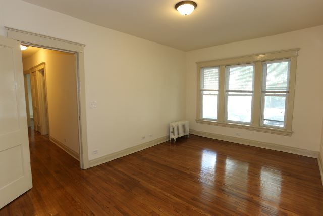 4716 North Racine Avenue, Unit 2E Chicago, IL 60640 - Photo 15 of 19 an empty room with wooden floor and windows