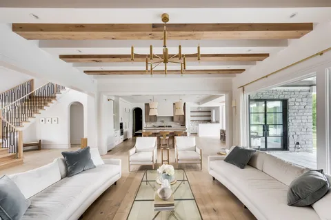 a kitchen with stainless steel appliances kitchen island granite countertop a table chairs in it and white cabinets