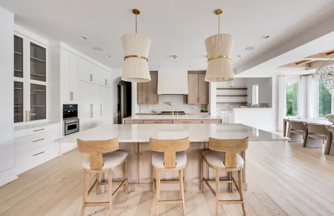 a large kitchen with kitchen island a large counter top space a sink a window and stainless steel appliances