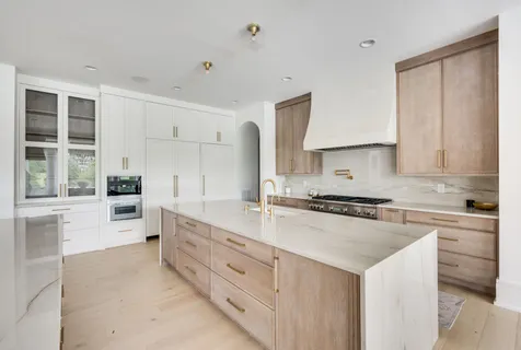 a kitchen with white cabinets a sink and appliances