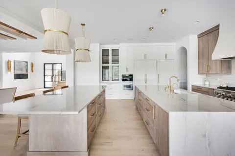 a large white kitchen with a large counter top appliances and cabinets