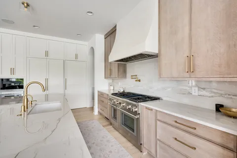 a kitchen with stainless steel appliances kitchen island granite countertop a sink and a cabinets