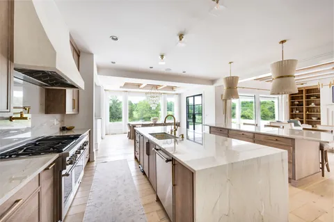 a dining room with wooden floor a chandelier a wooden table and chairs