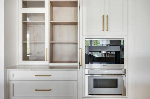 a view of kitchen with stainless steel appliances cabinets and window