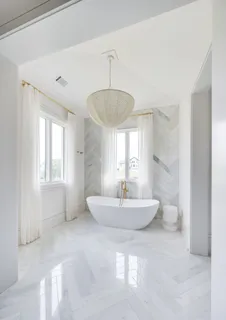 a bathroom with double vanity sinks a vanity a mirror and a bathtub
