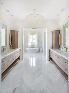 a large living room with stainless steel appliances kitchen island granite countertop furniture a fireplace and a chandelier