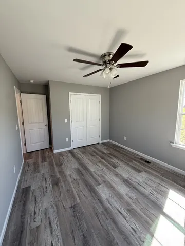 a view of empty room with wooden floor