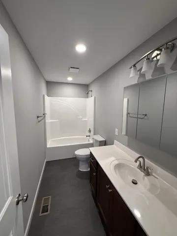 a bathroom with a double vanity sink mirror and bathtub