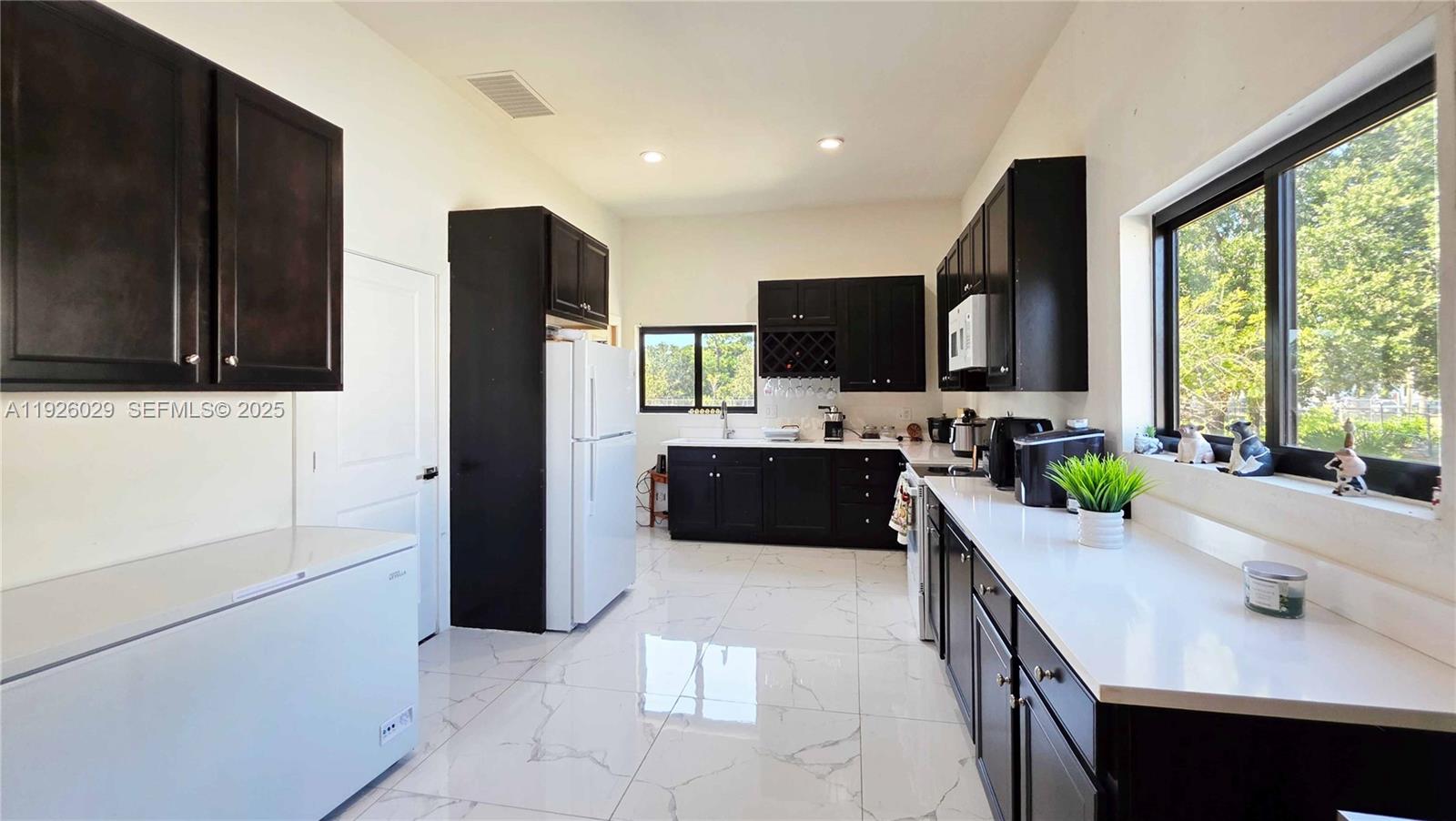 527 Perimeter Road Clewiston, FL 33440 - Photo 13 of 40 a kitchen with kitchen island a sink a counter top space appliances and cabinets