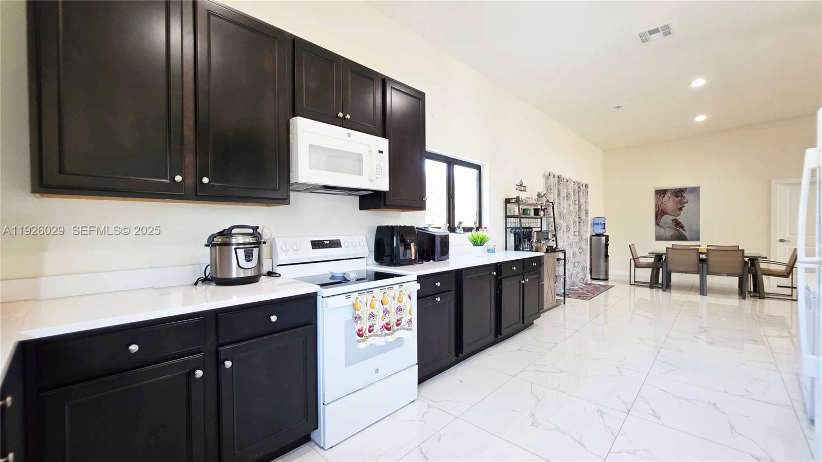 527 Perimeter Road Clewiston, FL 33440 - Photo 14 of 40 a kitchen with a sink a stove and cabinets