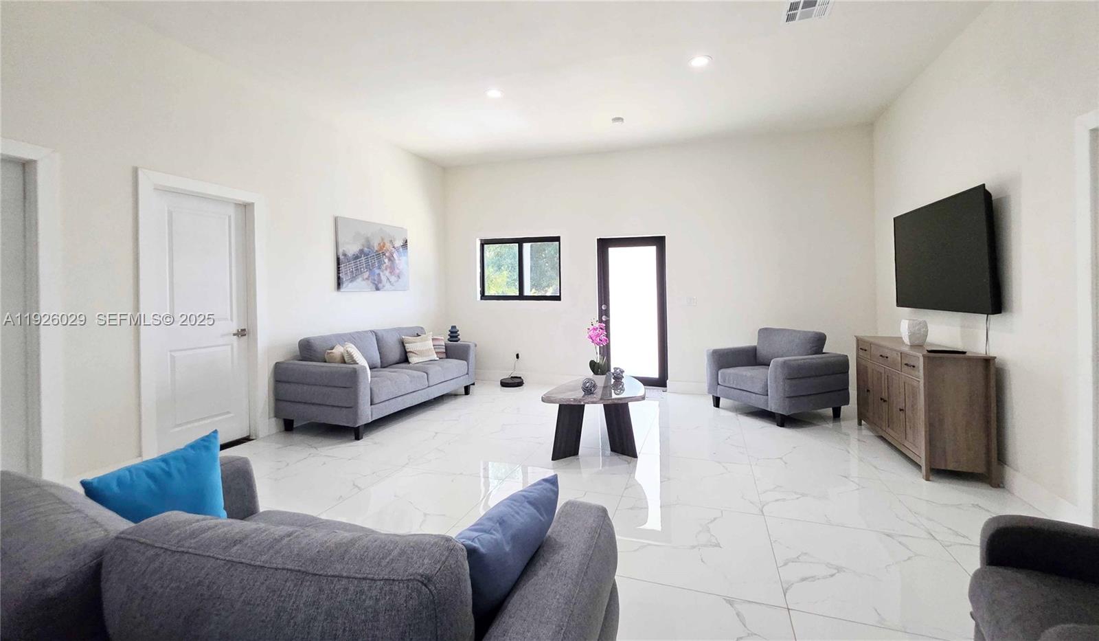 527 Perimeter Road Clewiston, FL 33440 - Photo 19 of 40 a living room with furniture and a flat screen tv