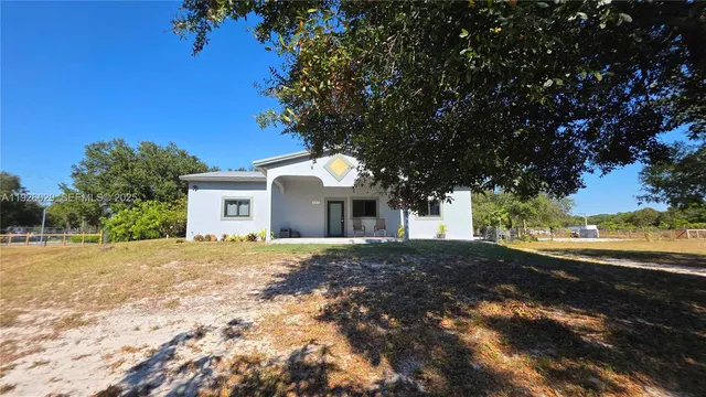a front view of a house with a yard and trees