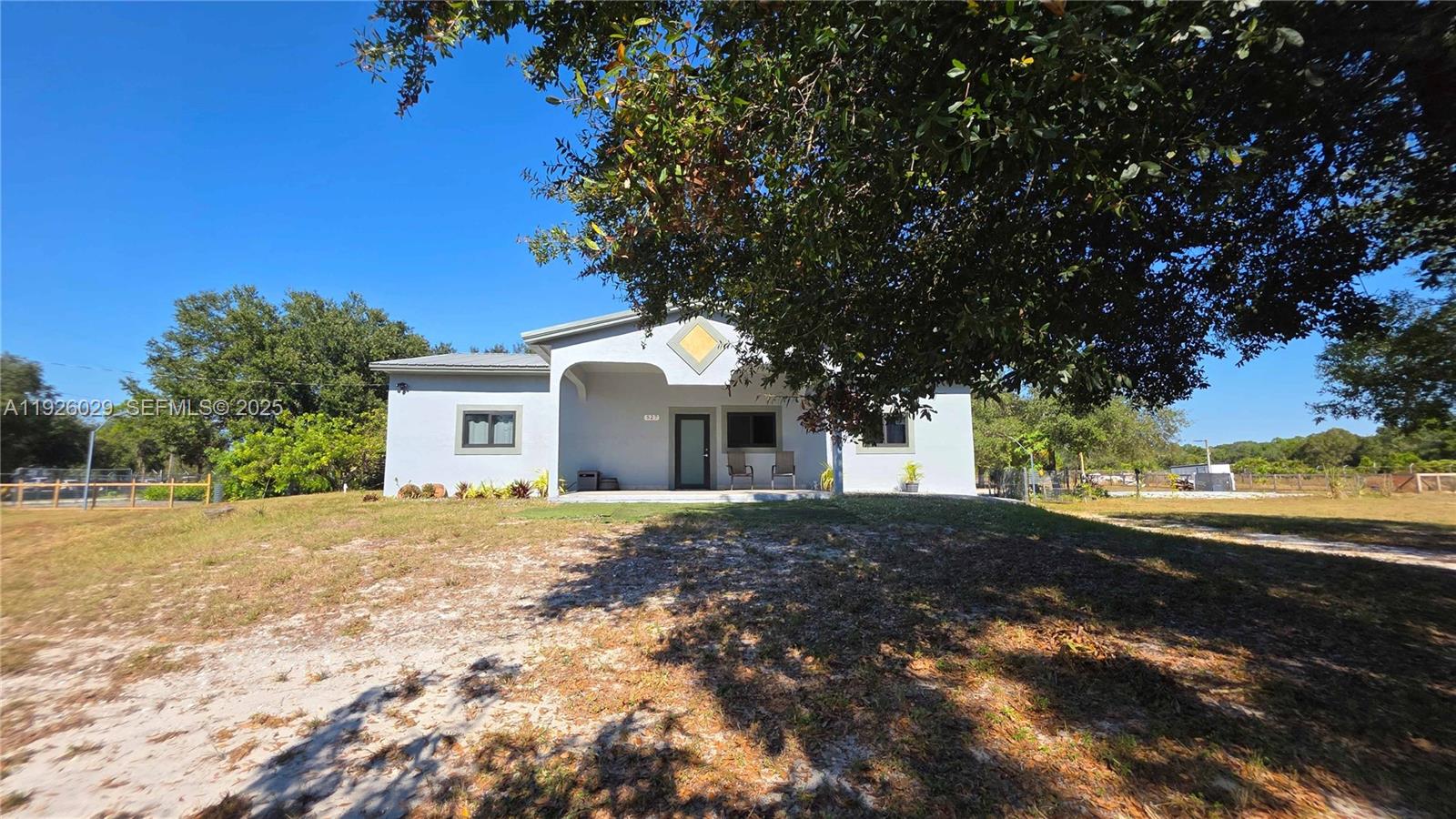 527 Perimeter Road Clewiston, FL 33440 - Photo 27 of 40 a front view of a house with a yard and trees
