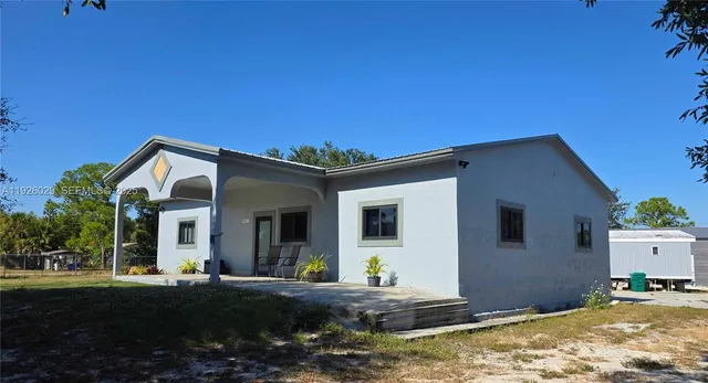 a view of a house with backyard and sitting area