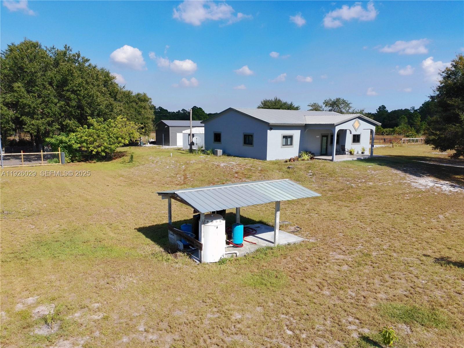 527 Perimeter Road Clewiston, FL 33440 - Photo 35 of 40 a view of a house with a swimming pool and a yard