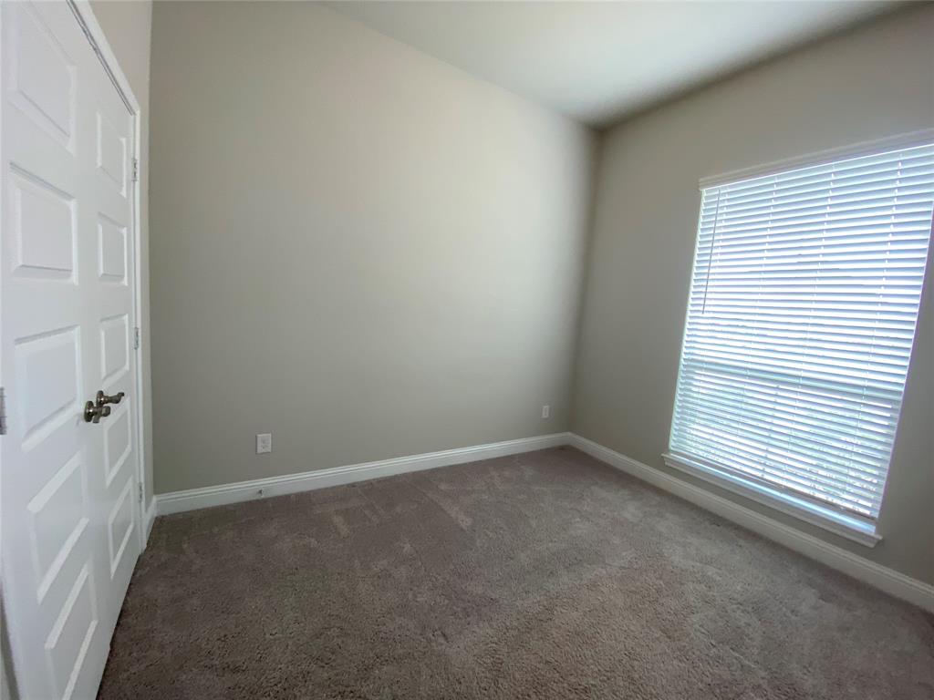209 Johnson Street Granbury, TX 76048 - Photo 37 of 40 Empty room with dark colored carpet