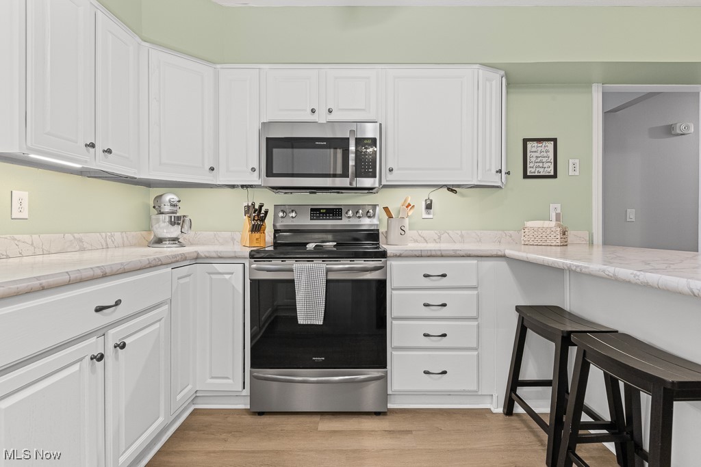 4000 Kenneth Road Stow, OH 44224 - Photo 11 of 50 Kitchen with appliances with stainless steel finishes, white cabinetry, and light wood-style floors