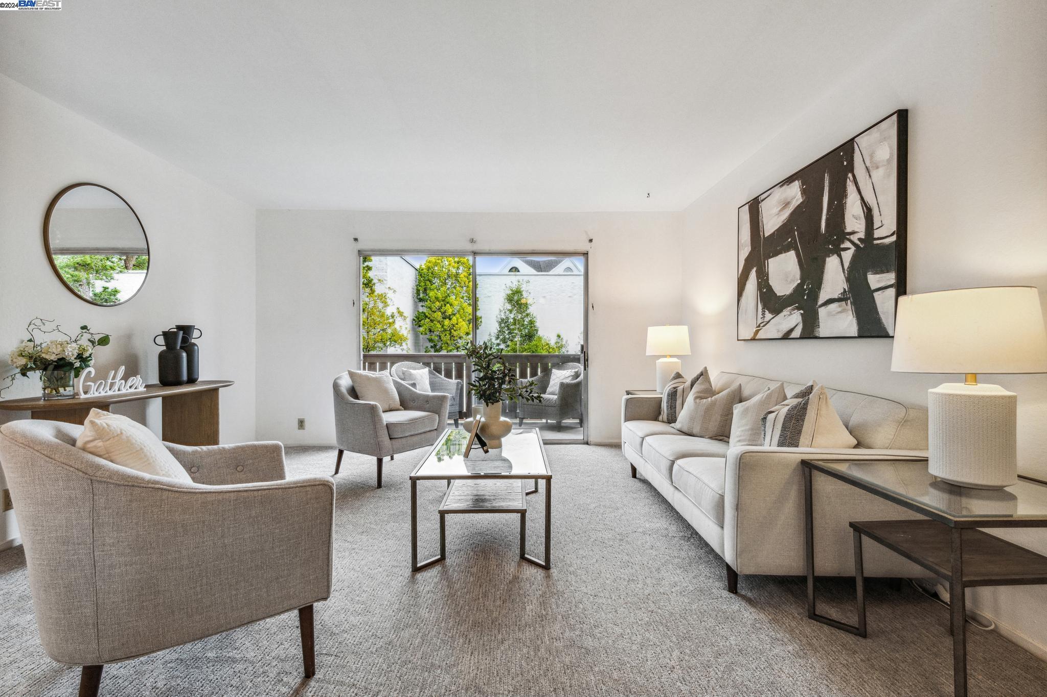 a living room with furniture a lamp wooden floor and a large window