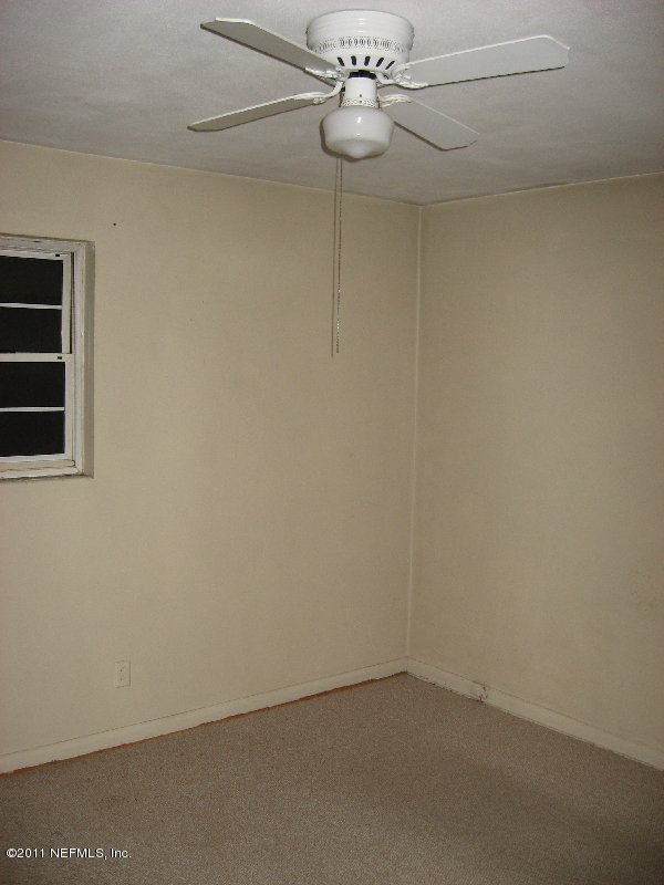 6732 Heidi Road Jacksonville, FL 32277 - Photo 6 of 10 an empty room with a chandelier fan