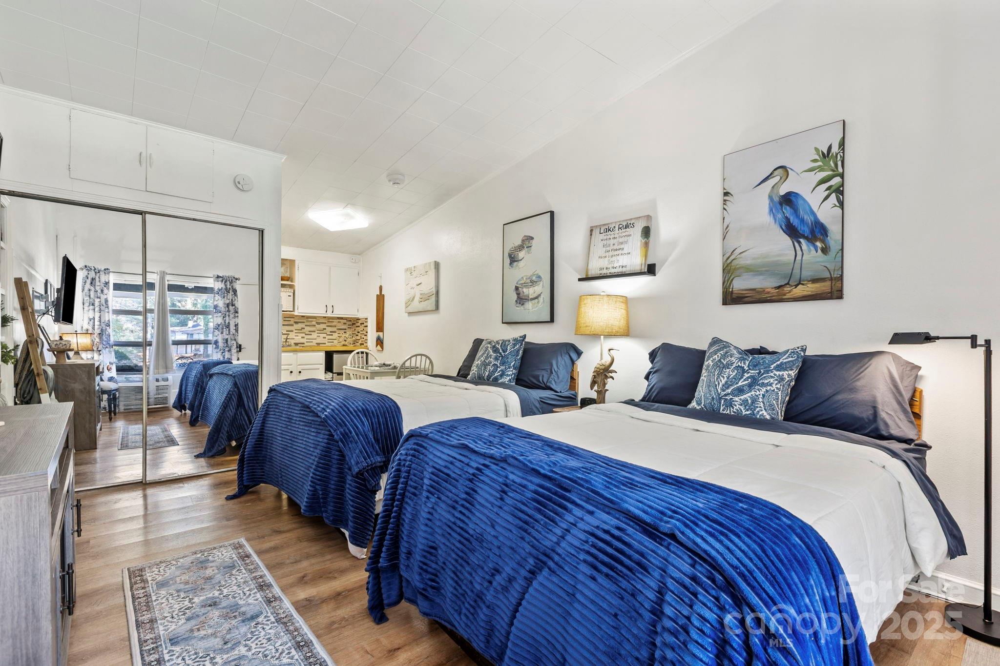 a large bedroom with bed and glass windows