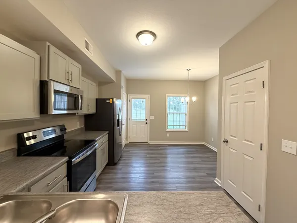 a kitchen with stainless steel appliances granite countertop a refrigerator and a stove