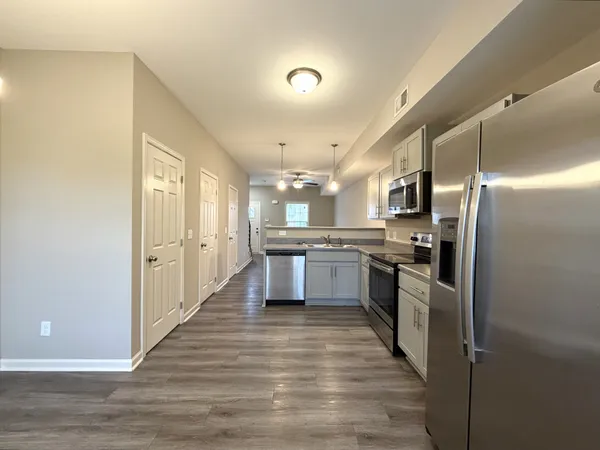 a large kitchen with a center island stainless steel appliances cabinets a sink and a counter top space