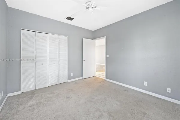 a view of an empty room with a ceiling fan