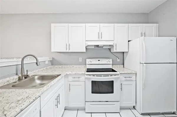 a kitchen with appliances a sink and cabinets