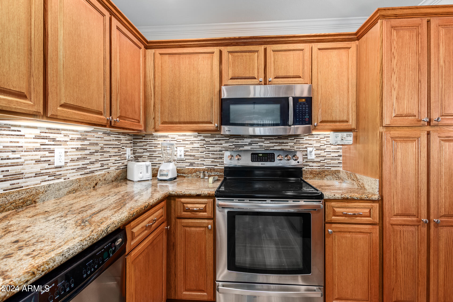 5131 Casper Road Mesa, AZ 85205 - Photo 16 of 32 a kitchen with granite countertop a stove top oven microwave and cabinets