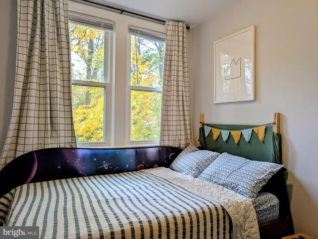 a bed sitting in a bedroom next to a window