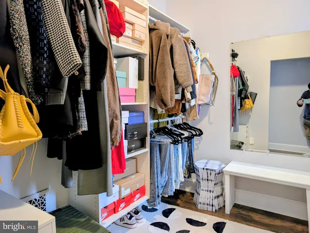 a view of walk in closet with clothes and shoes