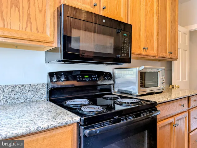 a kitchen with granite countertop a stove and a microwave