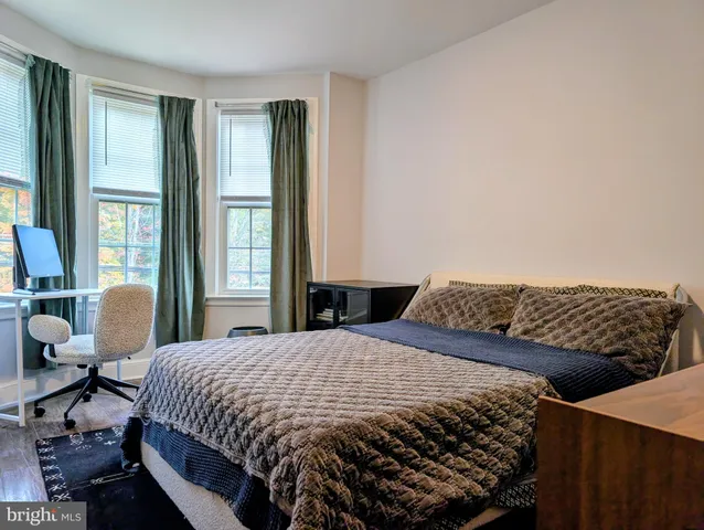 a bedroom with a bed and large windows