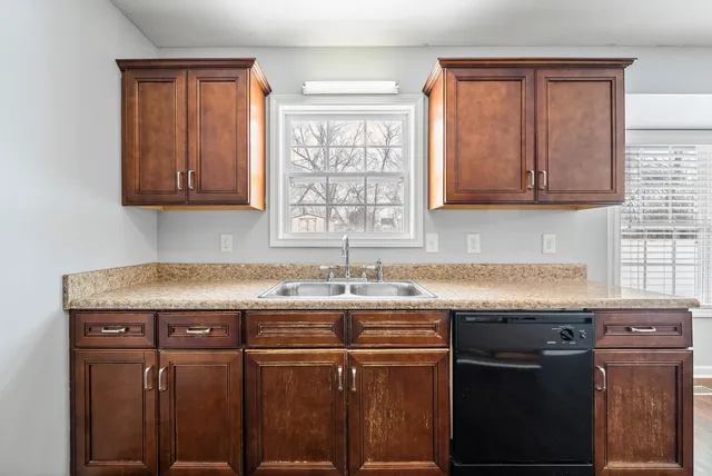 a kitchen with granite countertop a sink stove and cabinets