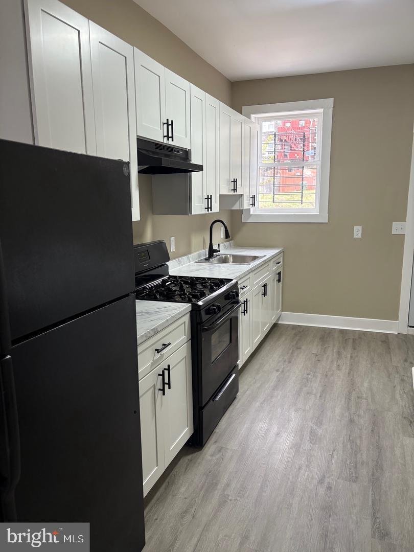 2114 Hollins Street Baltimore, MD 21223 - Photo 6 of 19 a kitchen with a sink stove and refrigerator