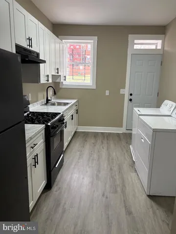 a kitchen with a sink stove top oven and cabinets