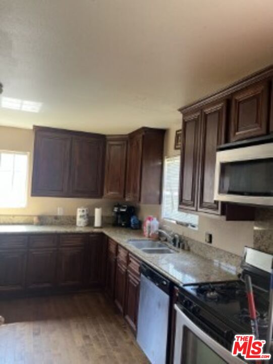 2223 East Oris Street Compton, CA 90222 - Photo 4 of 17 a kitchen with stainless steel appliances granite countertop a sink stove and microwave