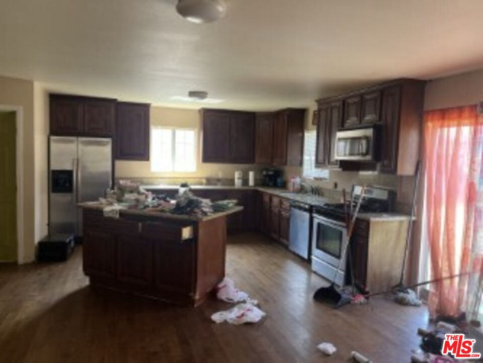 2223 East Oris Street Compton, CA 90222 - Photo 5 of 17 a kitchen with stainless steel appliances granite countertop a stove a refrigerator and a sink