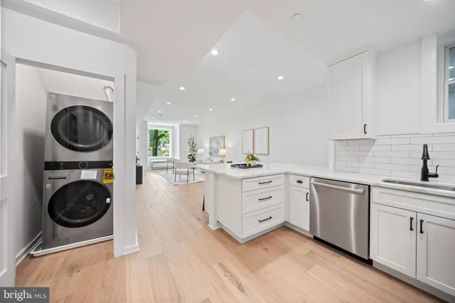 a view of a hallway with wooden floor and a bathroom
