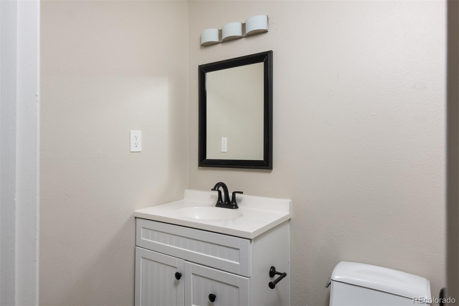 13766 Omega Circle Lone Tree, CO 80124 - Photo 18 of 37 a bathroom with a toilet sink and mirror