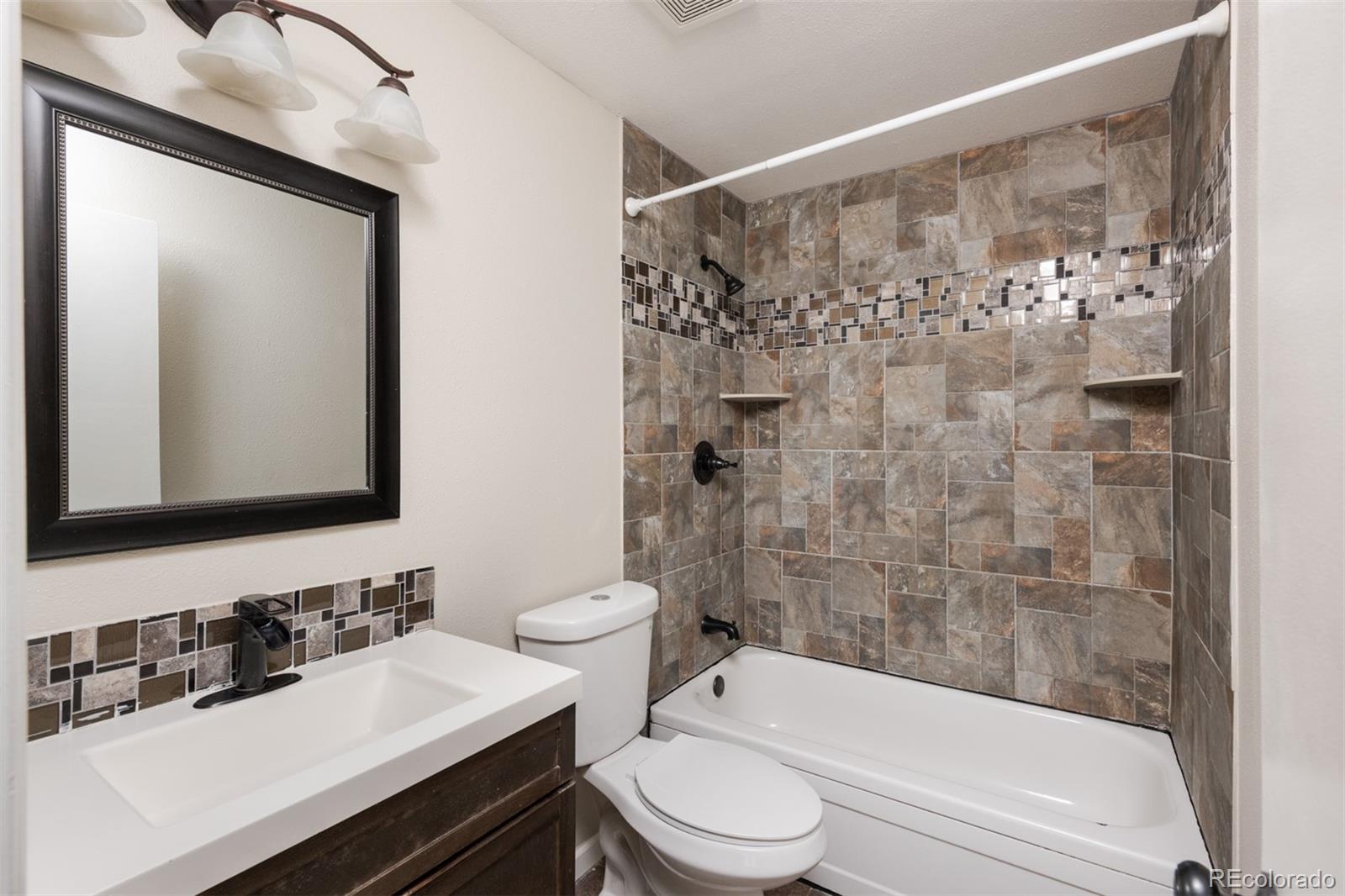 13766 Omega Circle Lone Tree, CO 80124 - Photo 22 of 37 a bathroom with a sink a toilet and shower