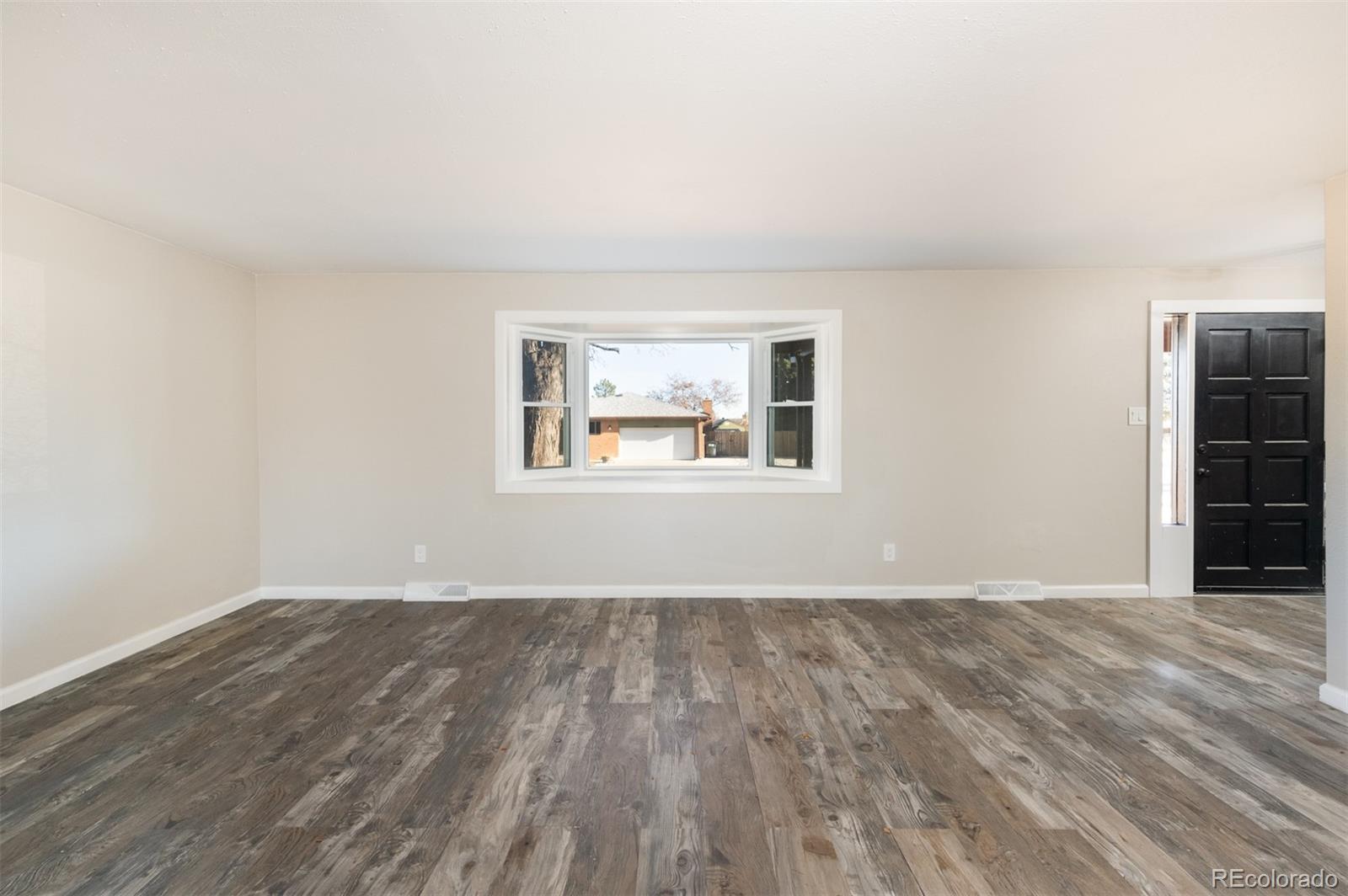 13766 Omega Circle Lone Tree, CO 80124 - Photo 7 of 37 a view of an empty room with wooden floor and a window
