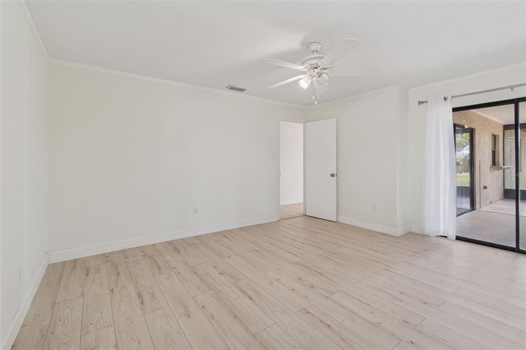 7337 Cambridge Way Clearwater, FL 33764 - Photo 13 of 28 a view of an empty room with wooden floor and a chandelier