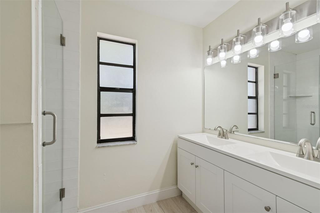 7337 Cambridge Way Clearwater, FL 33764 - Photo 15 of 28 a bathroom with a double vanity sink and a mirror