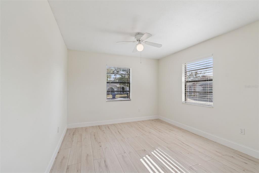 7337 Cambridge Way Clearwater, FL 33764 - Photo 18 of 28 wooden floor in an empty room with a window