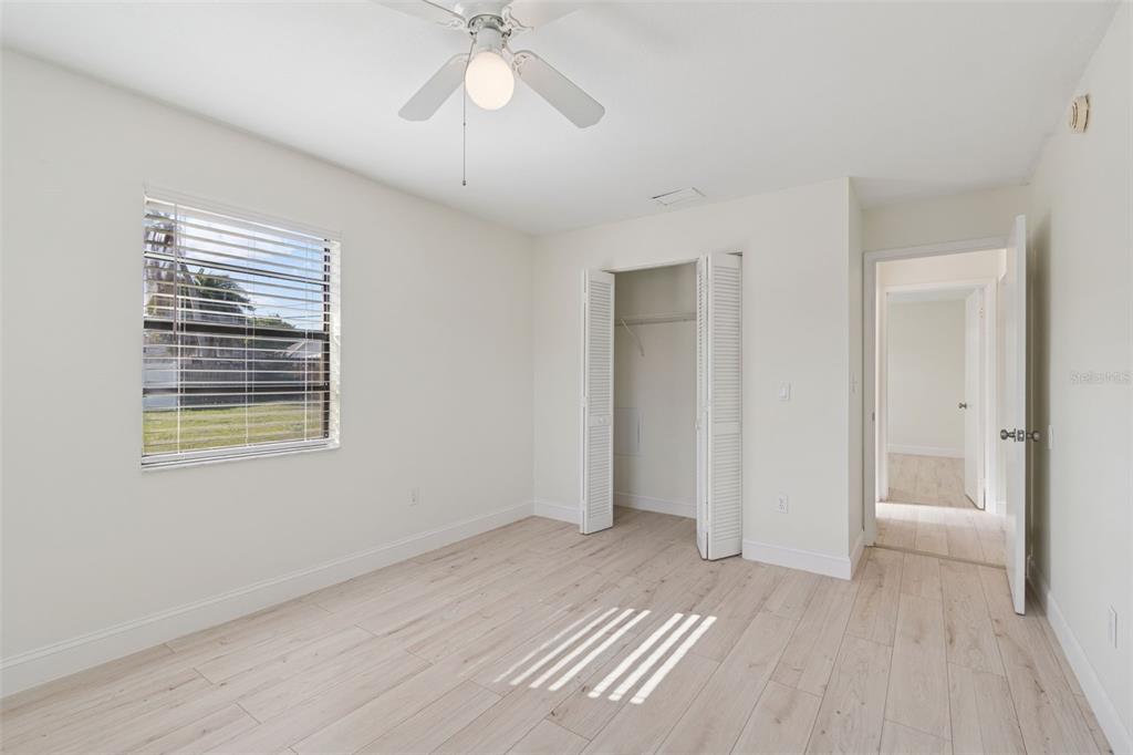 7337 Cambridge Way Clearwater, FL 33764 - Photo 19 of 28 a view of an empty room with wooden floor and a window