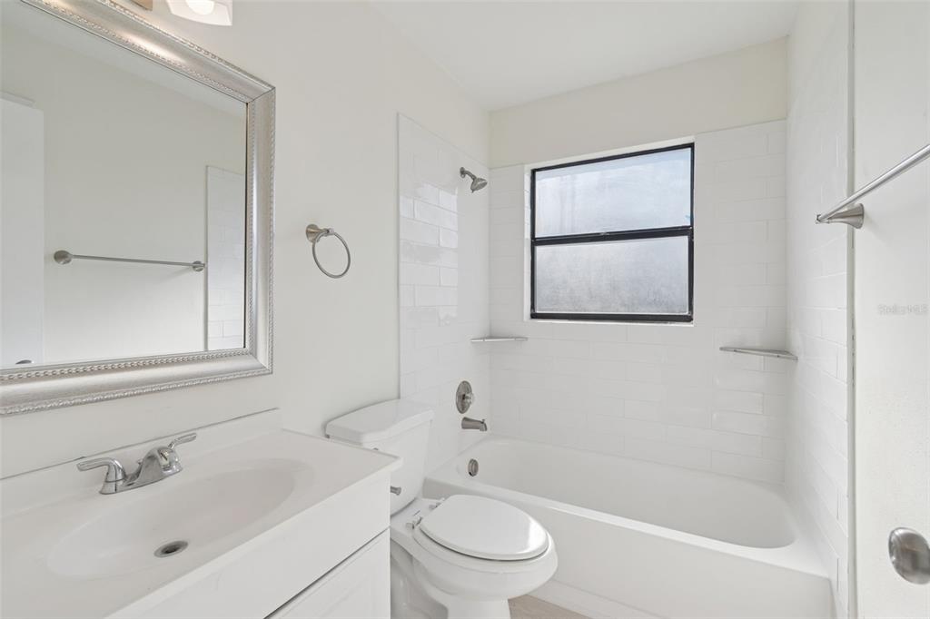 7337 Cambridge Way Clearwater, FL 33764 - Photo 20 of 28 a bathroom with a toilet a sink a mirror a shower and vanity