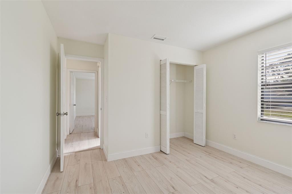 7337 Cambridge Way Clearwater, FL 33764 - Photo 23 of 28 a view of an empty room with wooden floor and a window