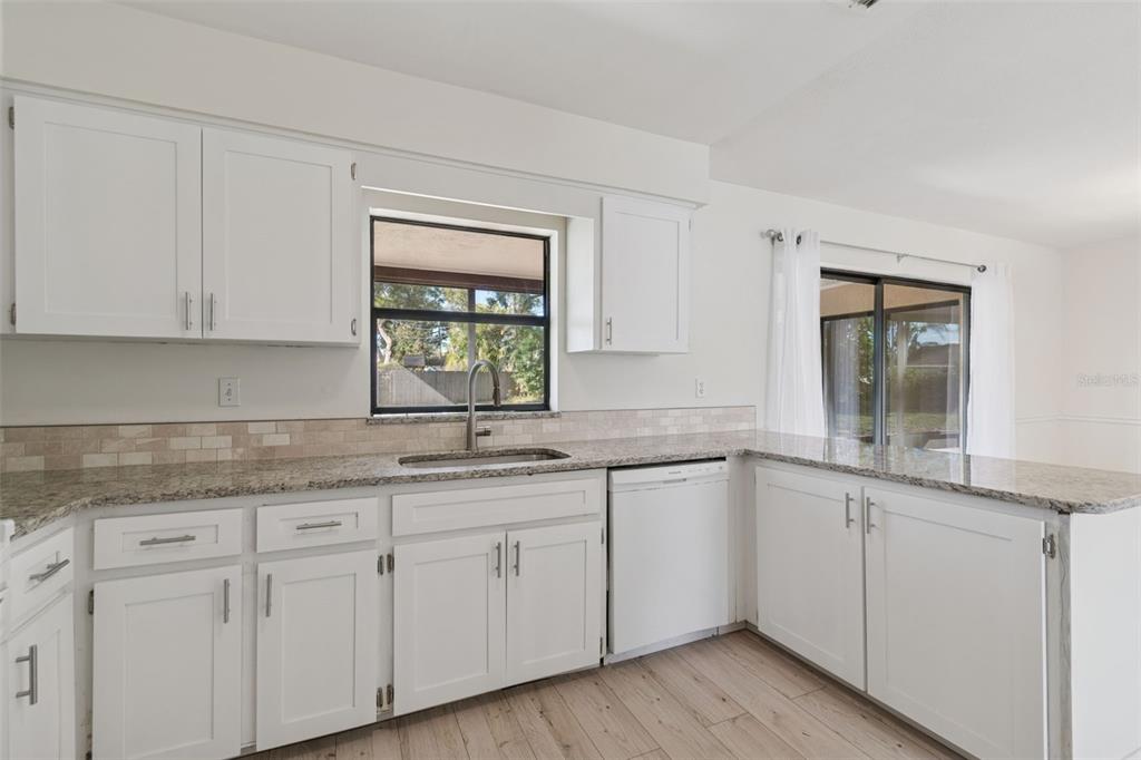 7337 Cambridge Way Clearwater, FL 33764 - Photo 8 of 28 a kitchen with granite countertop white cabinets white appliances and a sink