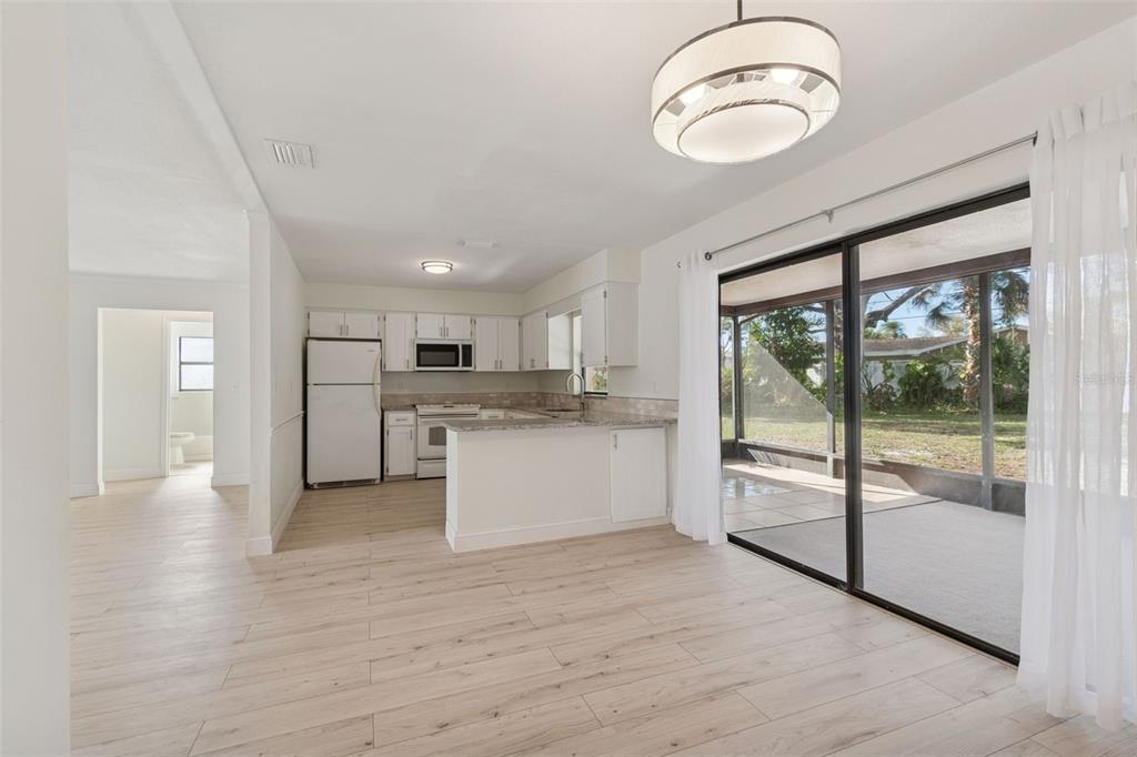 7337 Cambridge Way Clearwater, FL 33764 - Photo 9 of 28 a open kitchen with white cabinets and wooden floor